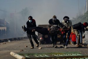 protestors carry an injured protestor to get to medical attention as they are dodging bullets, rubber bullets and teargas. credited to Faiz Abubaker.